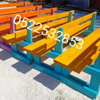 ספסלי עץ בגוונים שונים בדרך לעוד בית ספר בנהריה