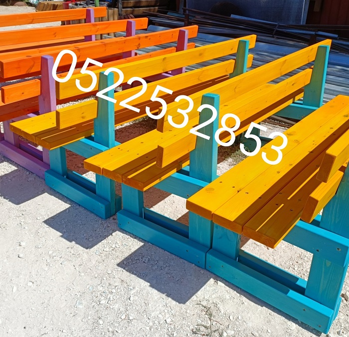 ספסלי עץ בגוונים שונים בדרך לעוד בית ספר בנהריה